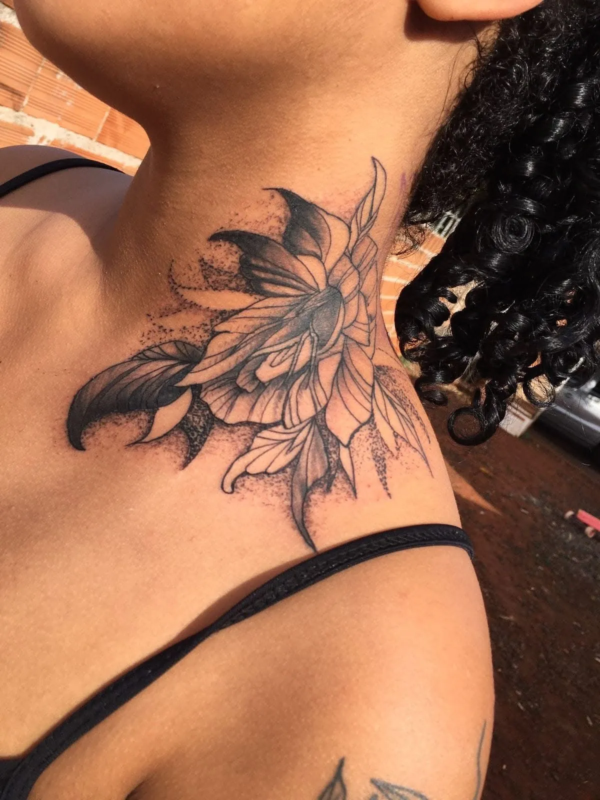 Tatuagem blackwork de flor com pontilhismo no pescoço