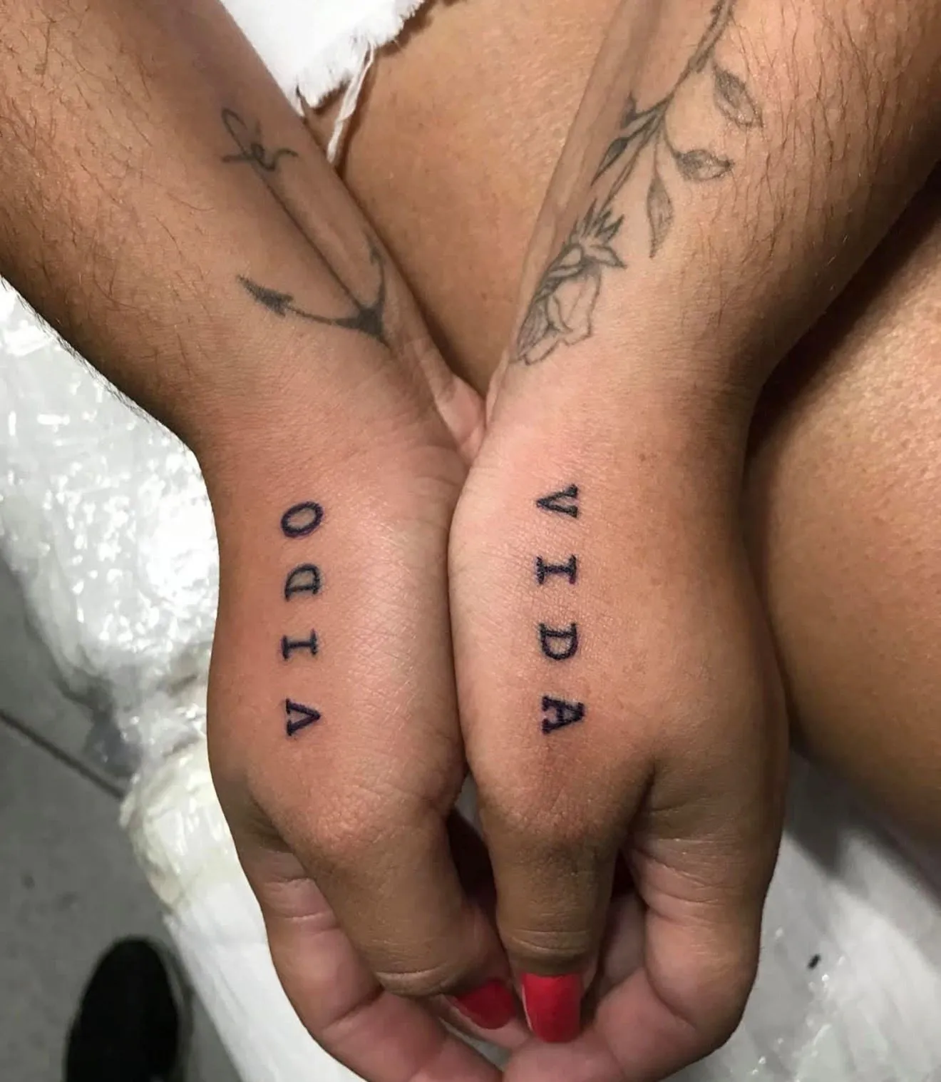 Tatuagem lettering da palavra Vida na lateral de duas mãos